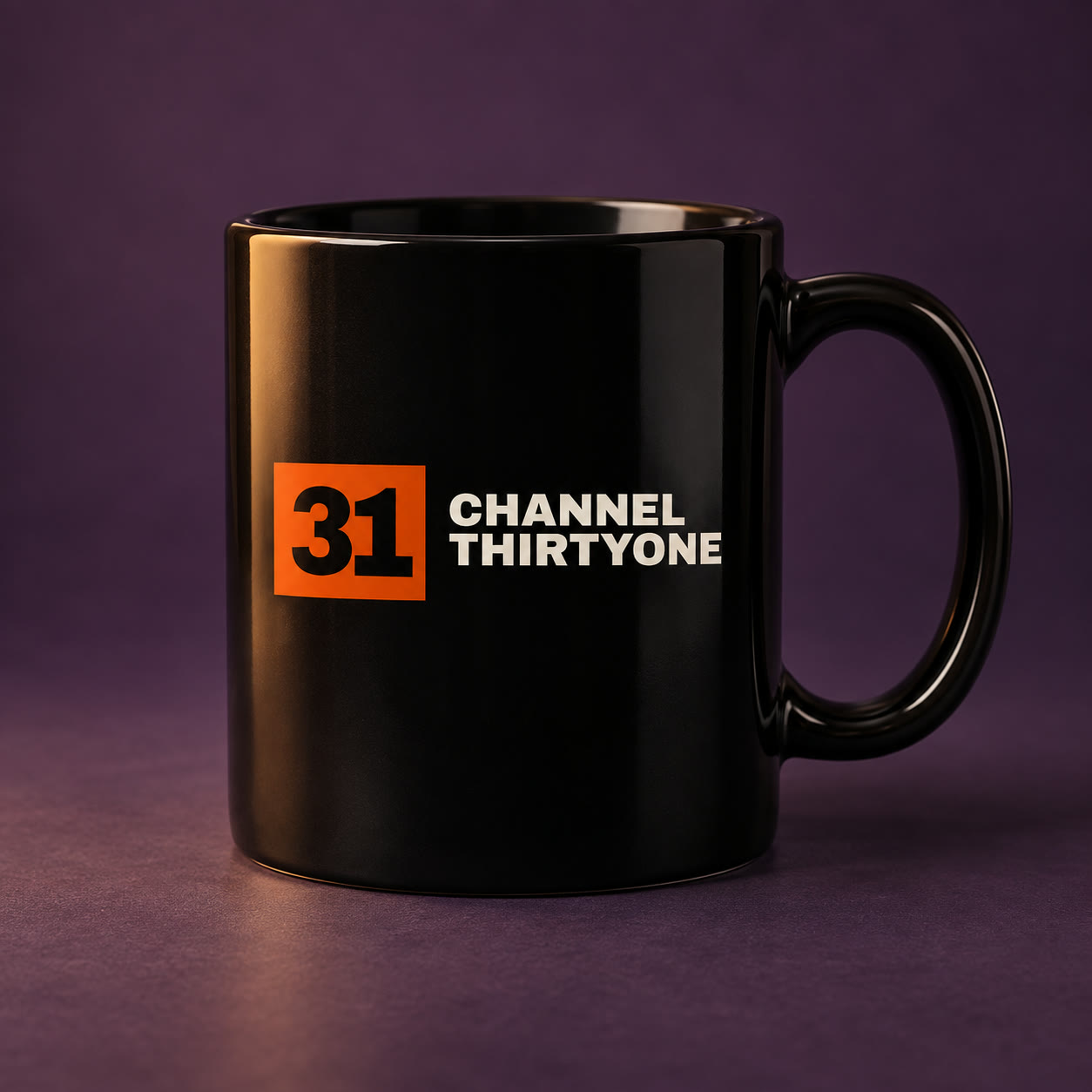 Black ceramic mug with the orange and bone Channel Thirtyone logo