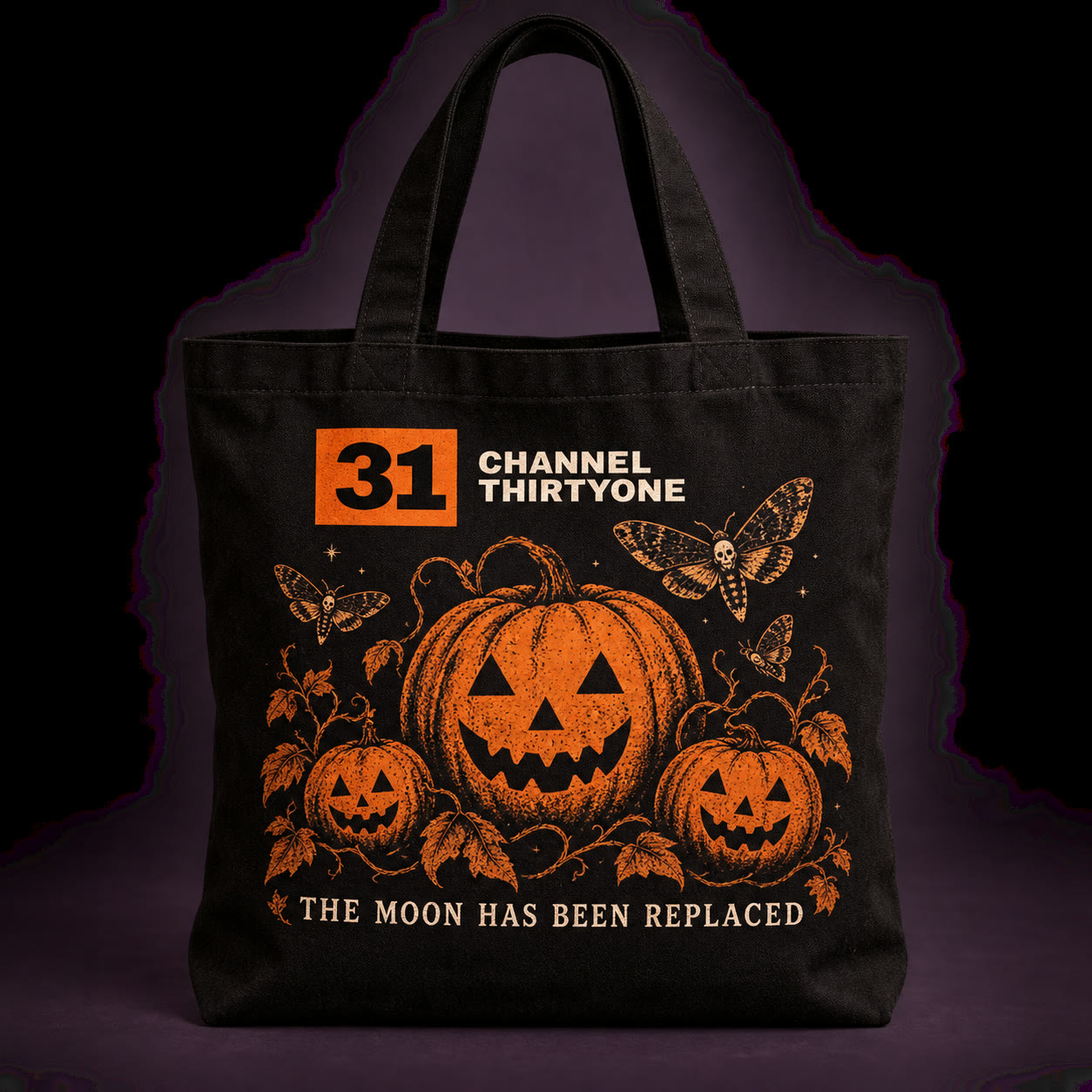 Black Channel Thirtyone Halloween tote with pumpkins, moths, and The Moon Has Been Replaced lettering